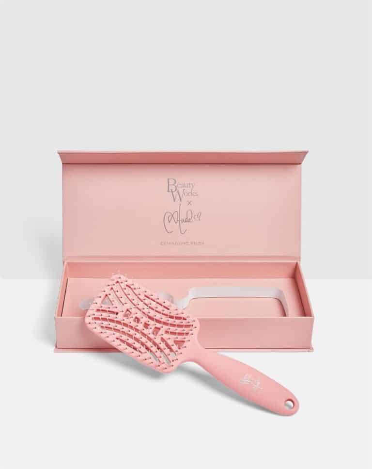 Pink detangling brush with a matching open box, labeled "Beauty Works x Molly-Mae."